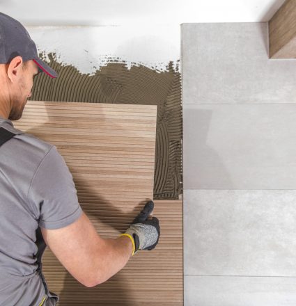 Caucasian Tiles Installer Caucasian Ceramic Tiles Installer at Work. Remodeling Bathroom Concept.