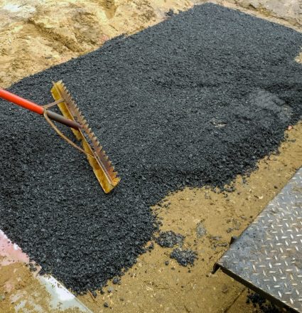 Worker Asphalting paver machine during Road street repairing works Worker on Asphalting paver machine during Road street repairing works