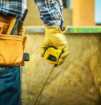 Construction Site Job Construction Site Job. Worker with Measurement Tape in Hand and Wearing Tools Belt. Industrial Theme.
