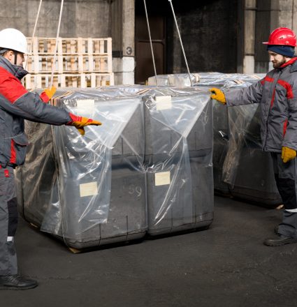 Workers Packing Construction Blocks Full length portrait of two factory workers packaging shipment units in industrial workshop, copy space